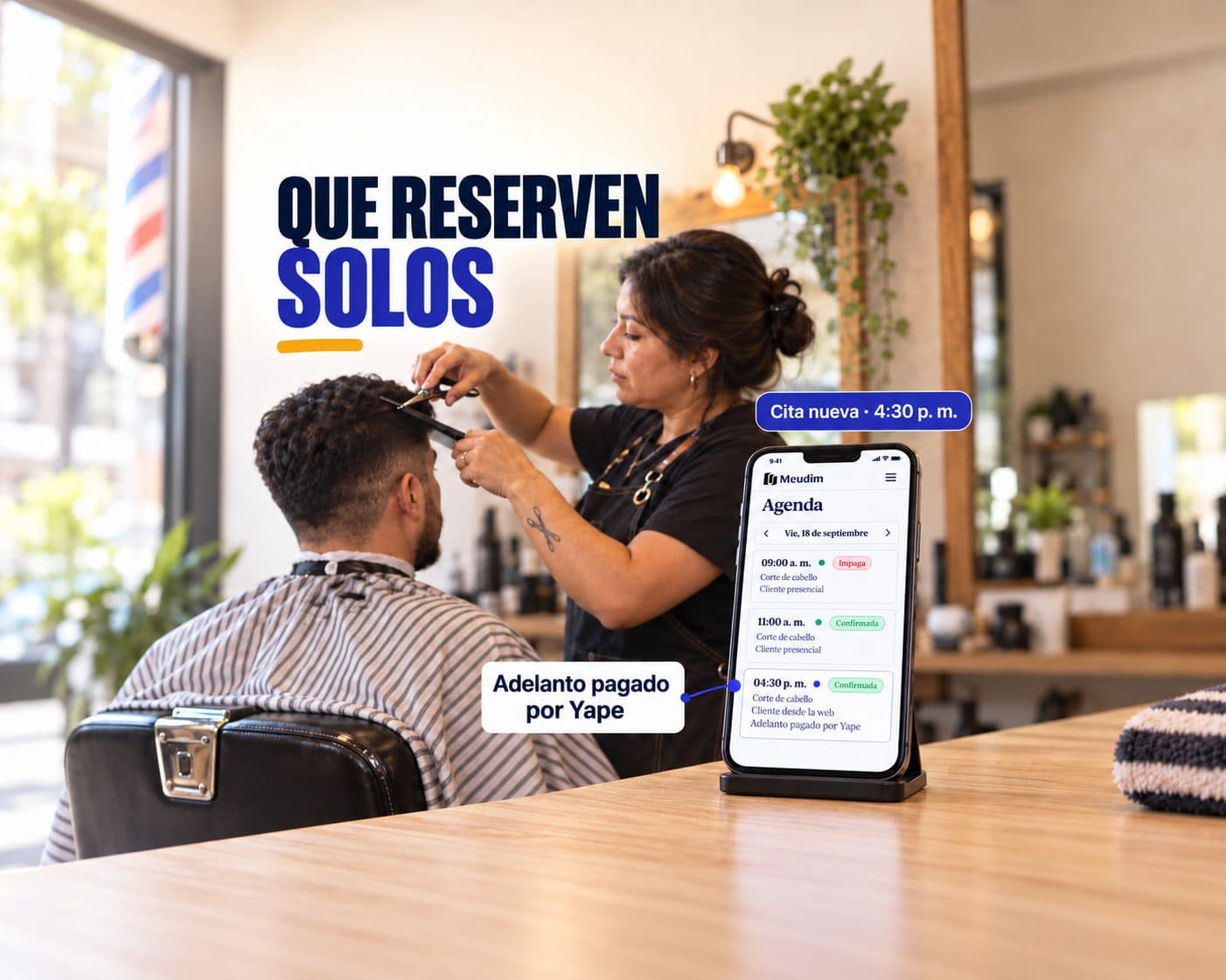 Barbera atendiendo a un cliente mientras su celular, apoyado en el mostrador, muestra una cita nueva en la agenda de Meudim: «Que reserven solos», «Cita nueva · 4:30 p. m.», «Adelanto pagado por Yape».